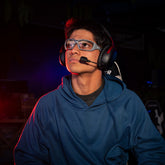 Gamer with a headset wearing AIM 44 gaming glasses with grey frames 