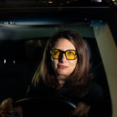 Woman driving at night wearing Ember night driving glasses
